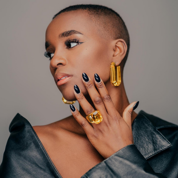 woman holds up hand showing beautiful amber ring.